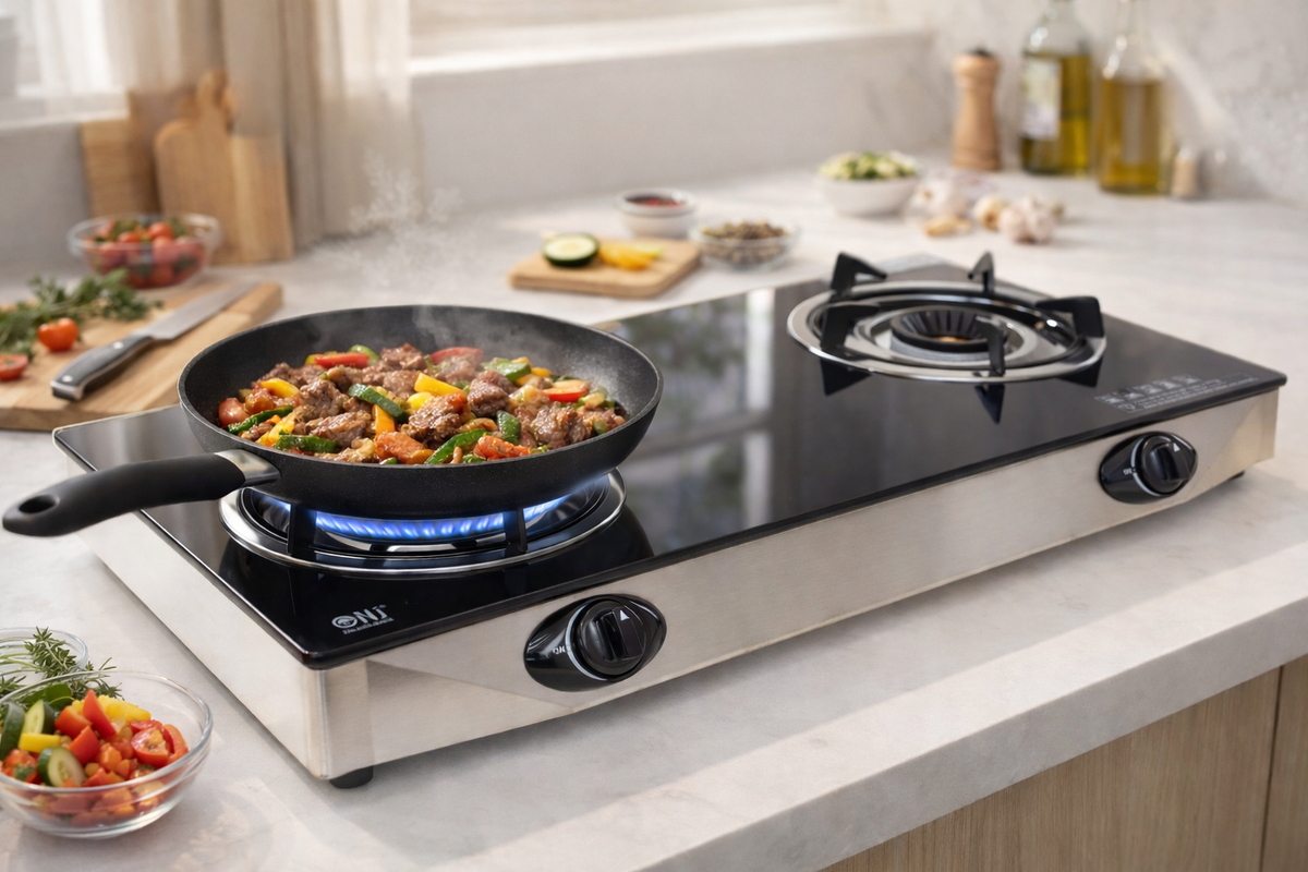 Portable double burner gas stove with a frying pan on a kitchen counter