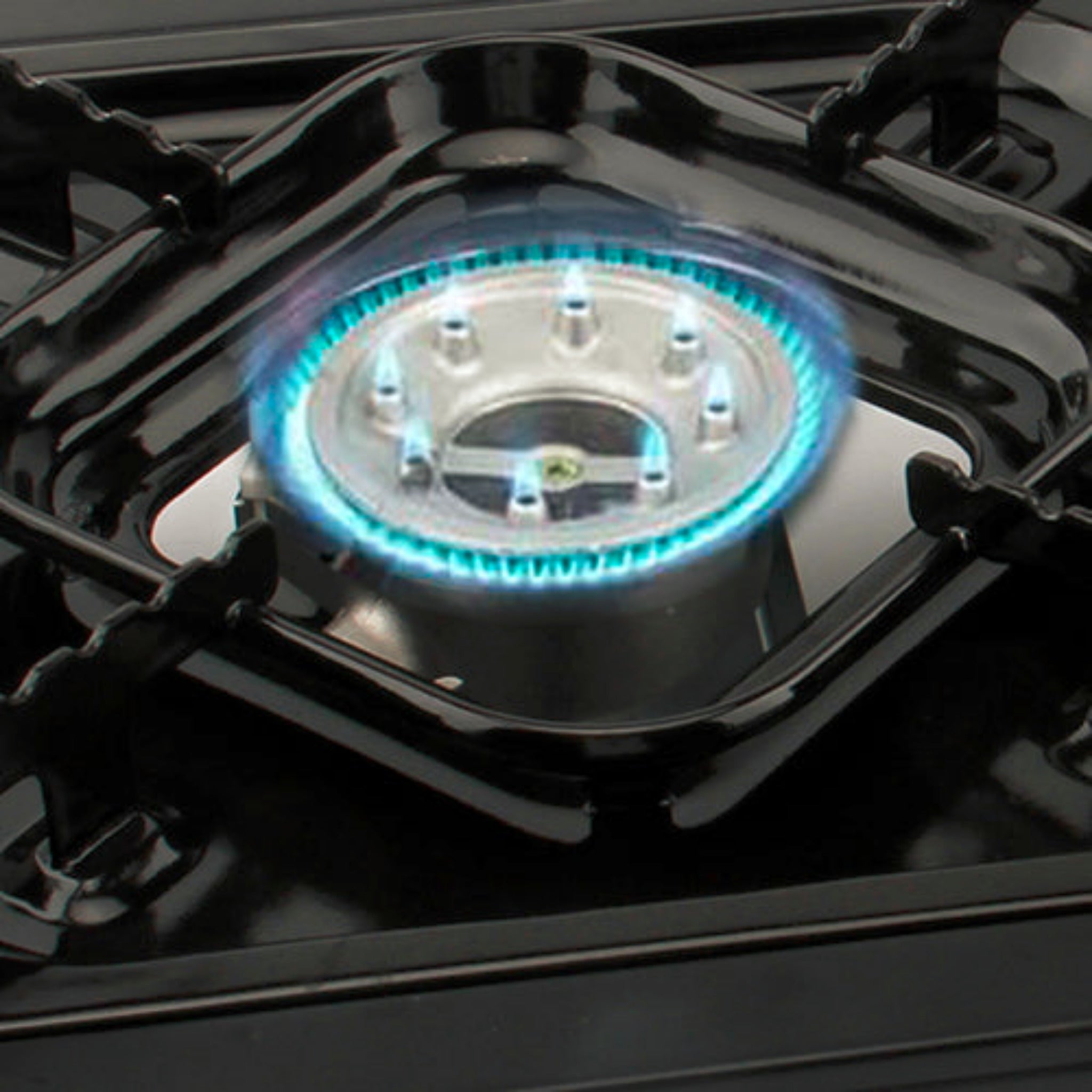 Gas stove burner with blue flames on a black stovetop