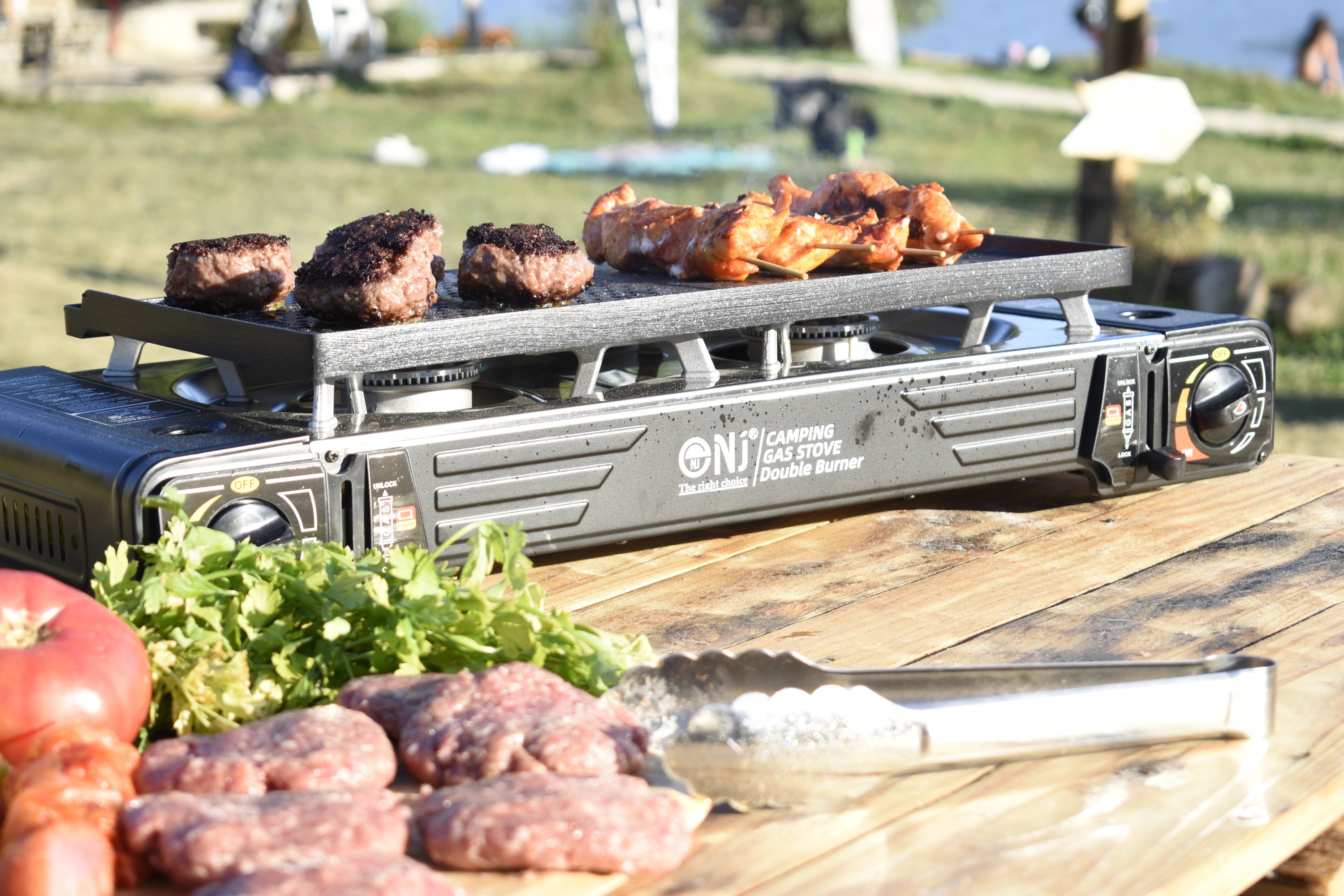 Portable grill with food on a wooden surface outdoors