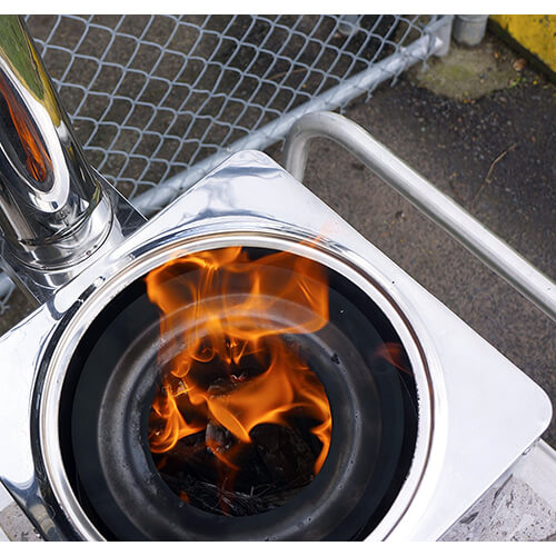 Close-up of a wood stove burner with flames inside