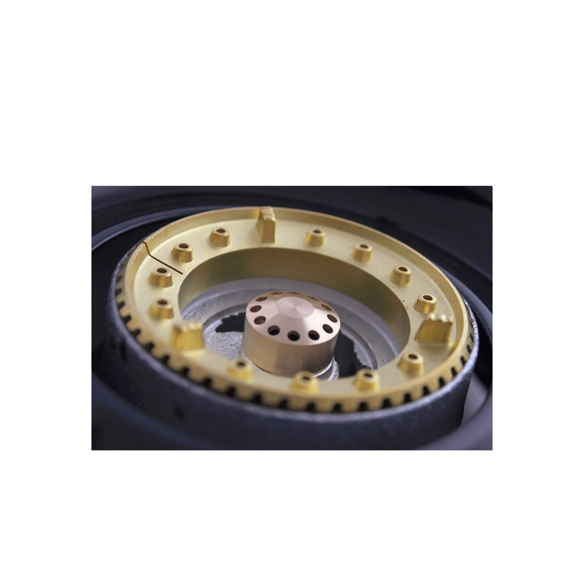 Close-up of a brass burner ring on a white background